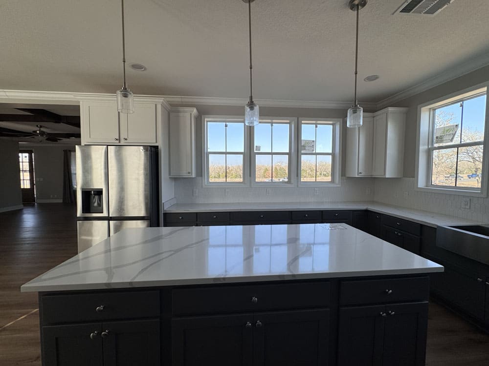 Large stone-look kitchen island and farmhouse sink in The Lilly II