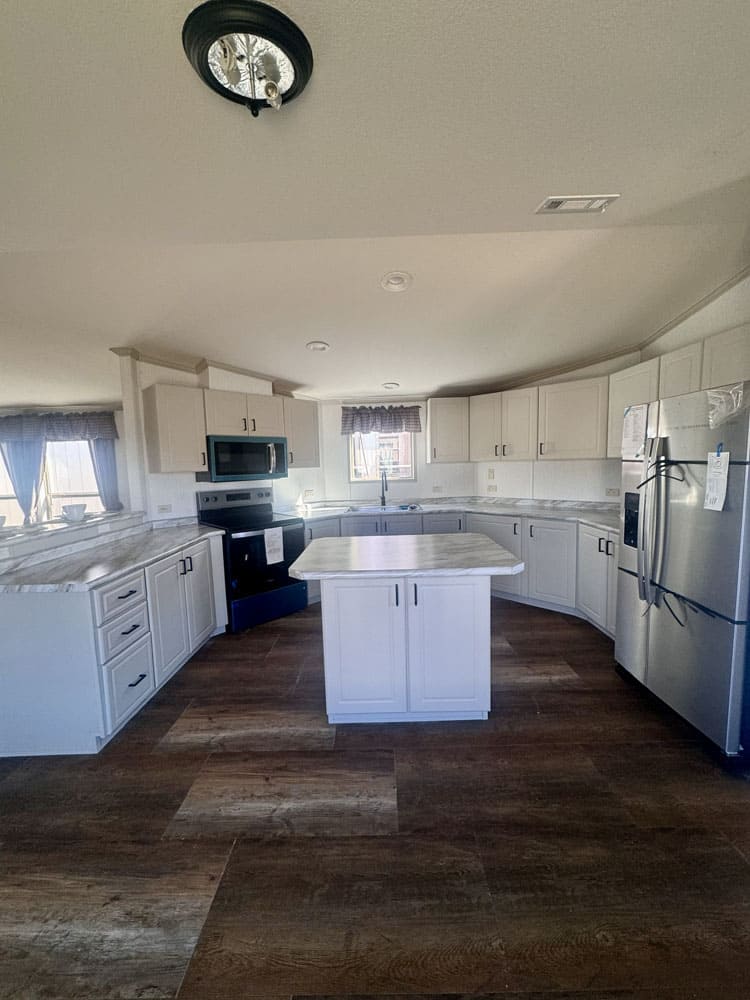 White cabinet kitchen with center island in a Conroe singlewide home