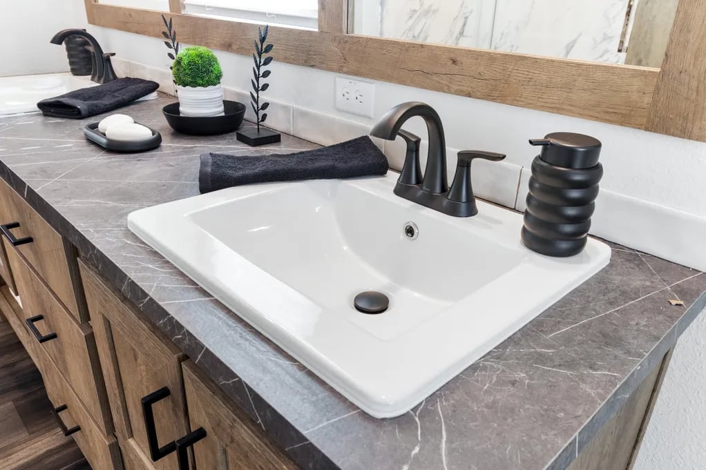 Bathroom sink with matte black faucet in the Clayton NXT Isabella Elite