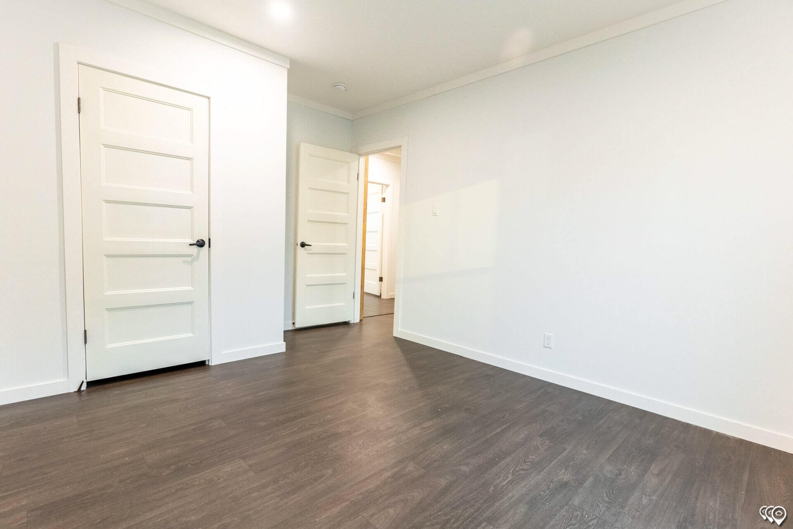 Secondary bedroom with closet and wood-look flooring in The Trinity CS-3242