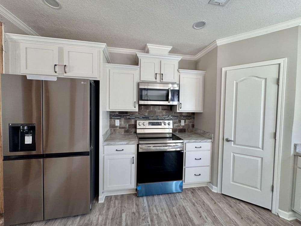 Stainless steel appliances and white cabinets in The Ace kitchen