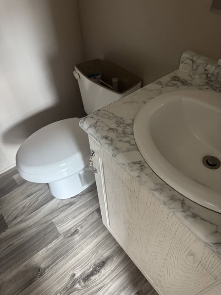 Private bathroom vanity and toilet in Legacy oilfield housing unit in Midland Odessa, TX