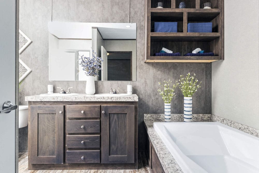Primary bath with double vanity, soaking tub and open linen storage in The Grant by Jessup Housing