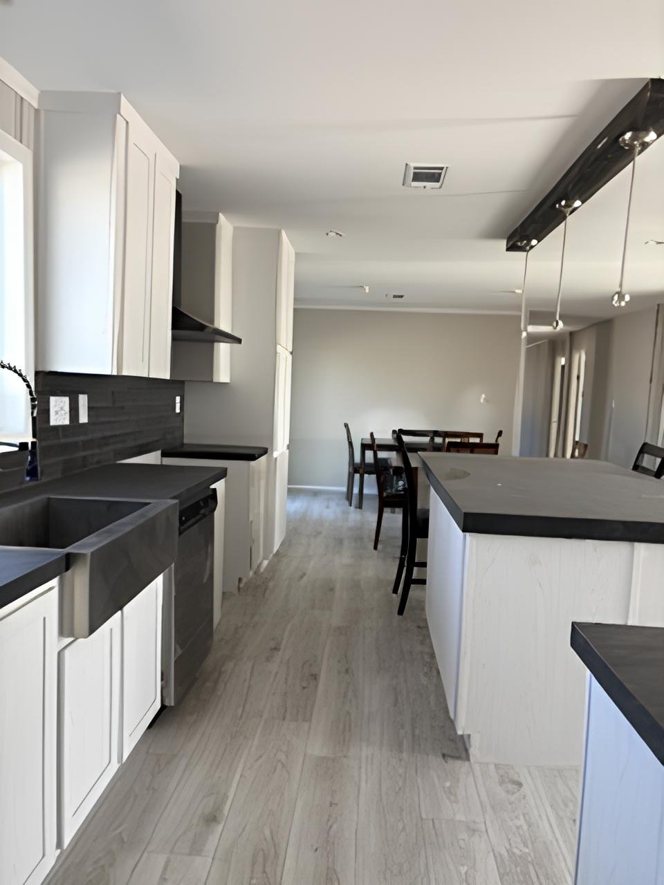 Open kitchen with farmhouse sink and oversized island in 32x76 West Texas doublewide