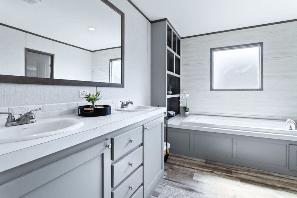 Primary bathroom with dual sinks and soaking tub in The Murphy manufactured home