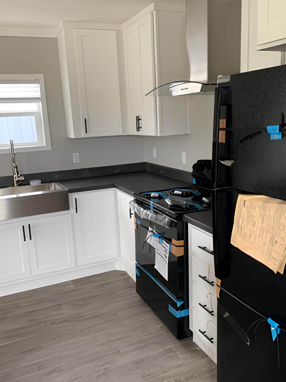 Bobby Jo kitchen with farmhouse sink, black appliances, and white cabinets