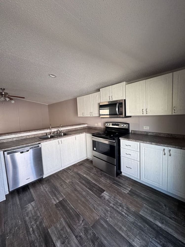 The Leyla kitchen with white cabinets and stainless appliances in Conroe, Texas