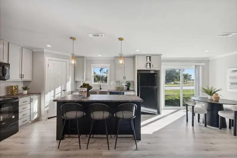 Kitchen island with bar seating beside the dining area in The Carol 4-bedroom home