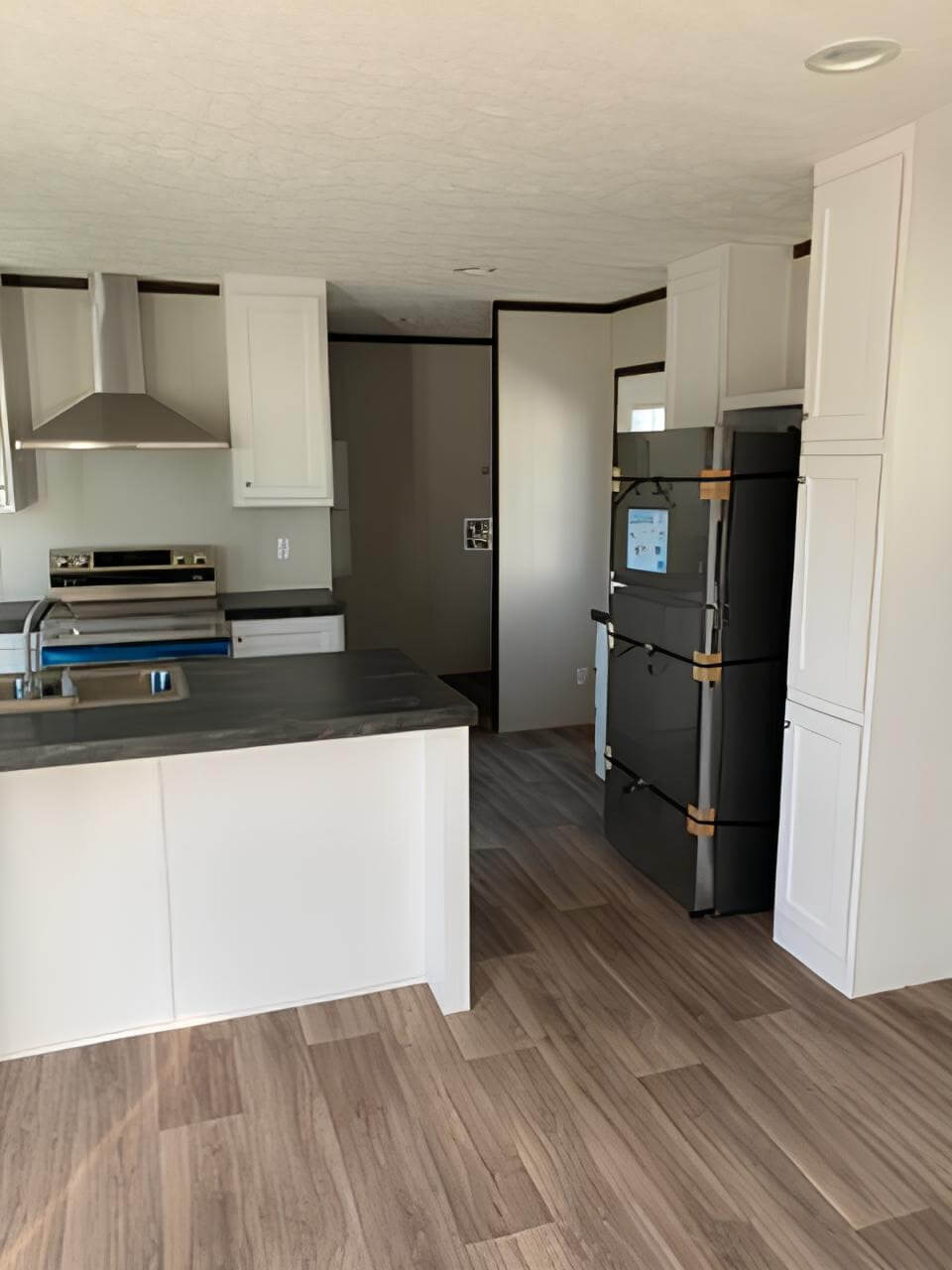 Bright kitchen with white cabinets and black appliances in The Spirit