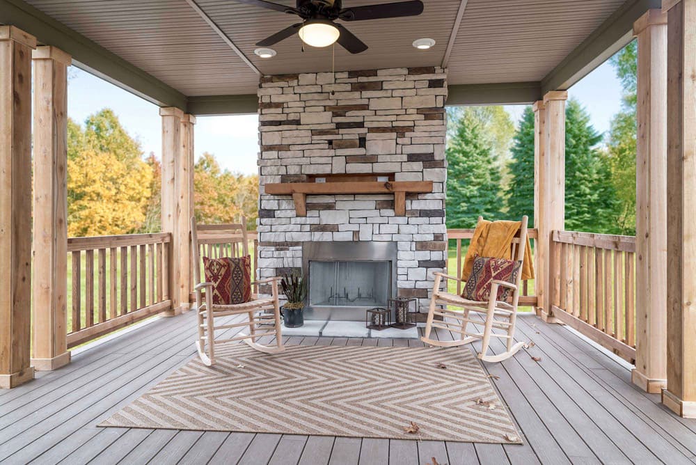 Covered porch fireplace and rocking chairs at The Nandina