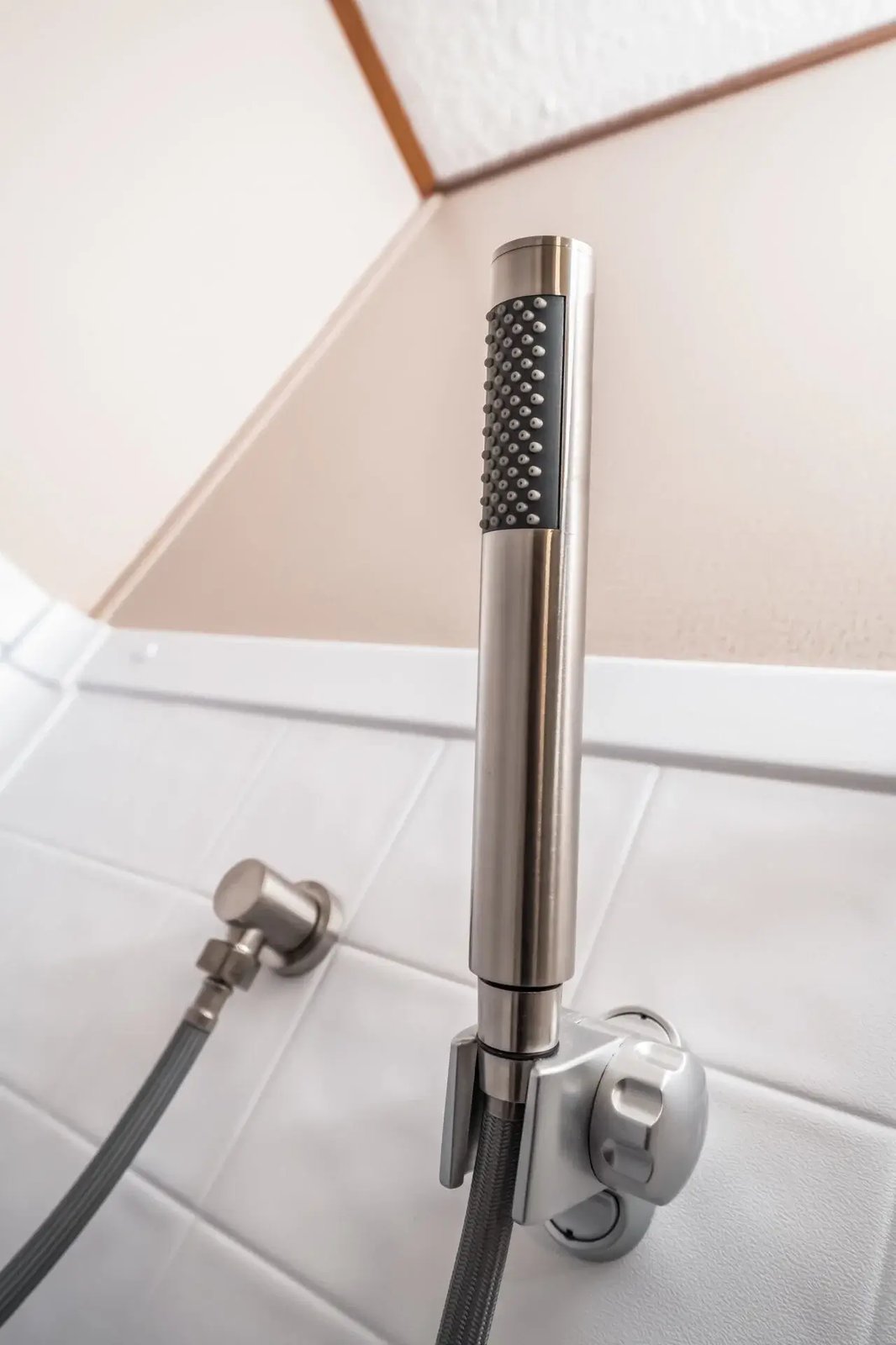 Close-up of the adjustable handheld shower fixture in a bathroom of The Lisa by Legacy Housing