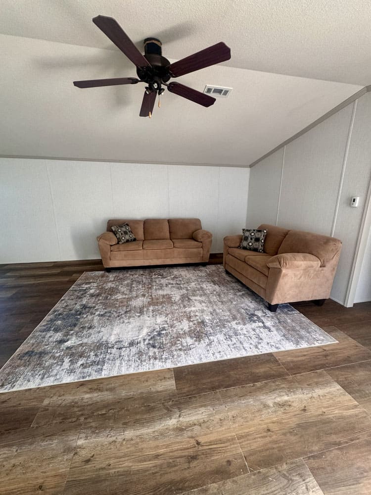 Spacious singlewide living room with vaulted ceiling and wood-look floors