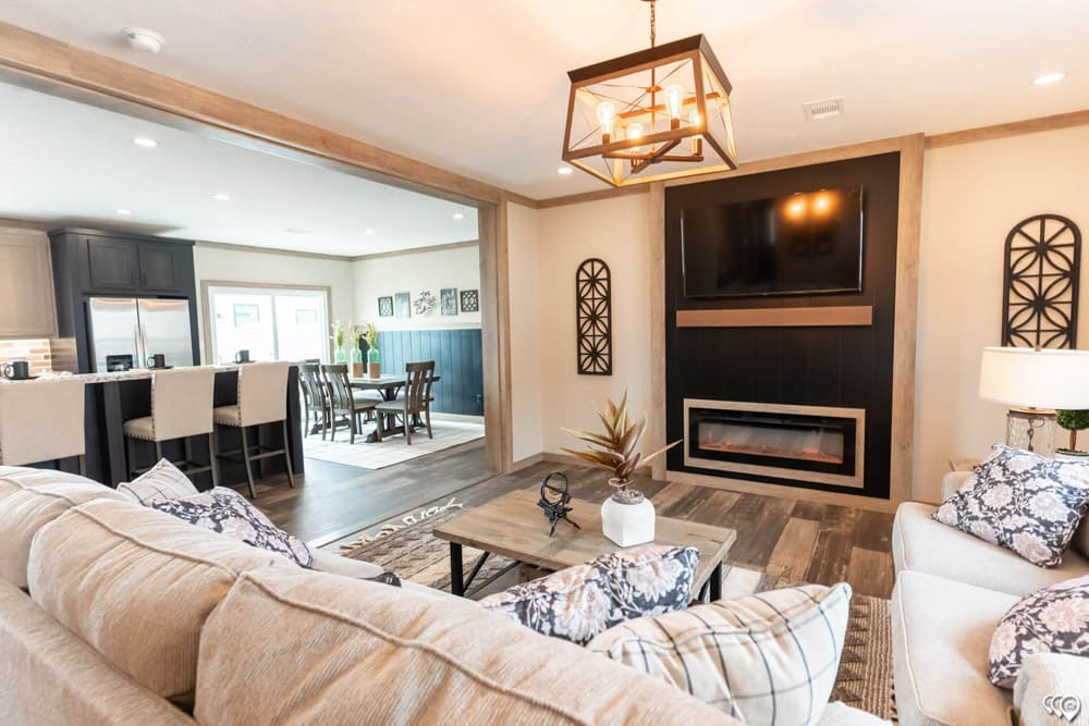 Doublewide living room with fireplace and entertainment wall at Premier Homes of Cedar Creek