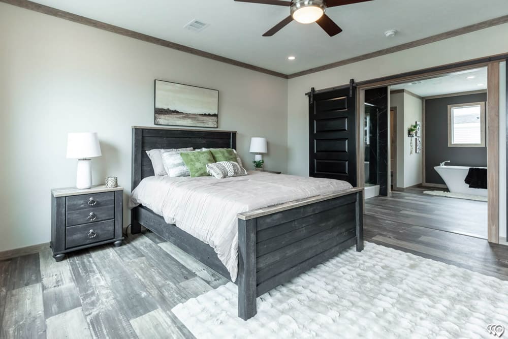 Primary bedroom with barn doors opening to a luxury bath in The Shoal Creek