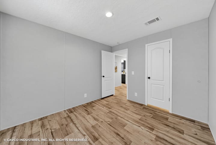 Secondary bedroom with wood-look flooring in The Vantage 3-bedroom manufactured home