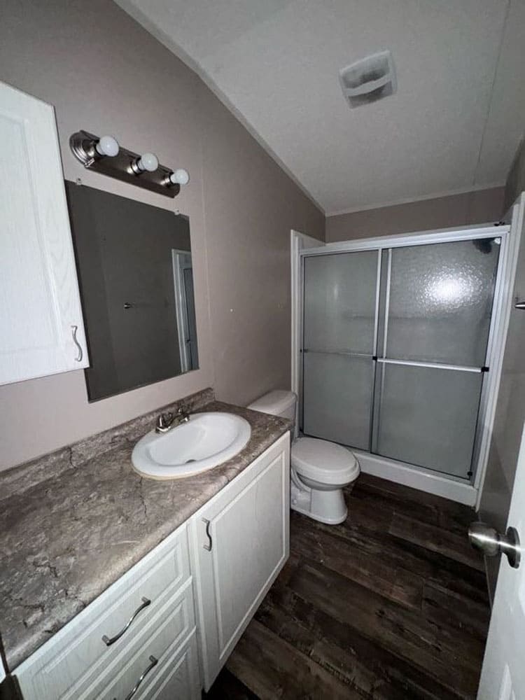Full bathroom with vanity and enclosed shower in The Leyla mobile home