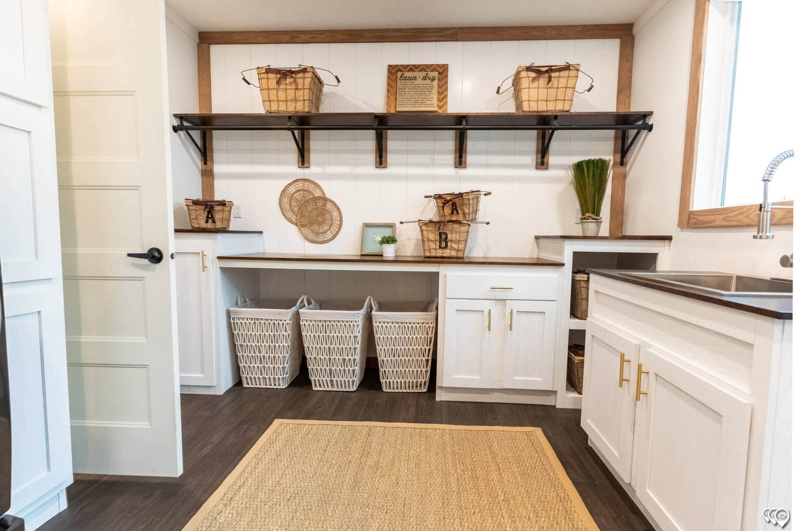 Utility room with sink, cabinetry, shelving, and laundry storage in The Trinity CS-3242
