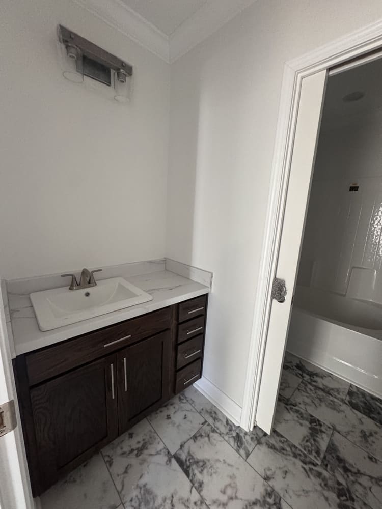 Guest bathroom vanity and tub entrance in The Shoreline manufactured home