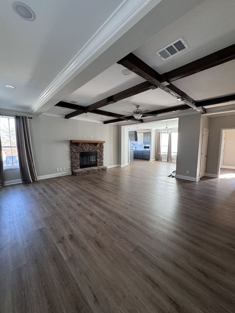 Open living room with wood beams and fireplace in The Lilly II modular home