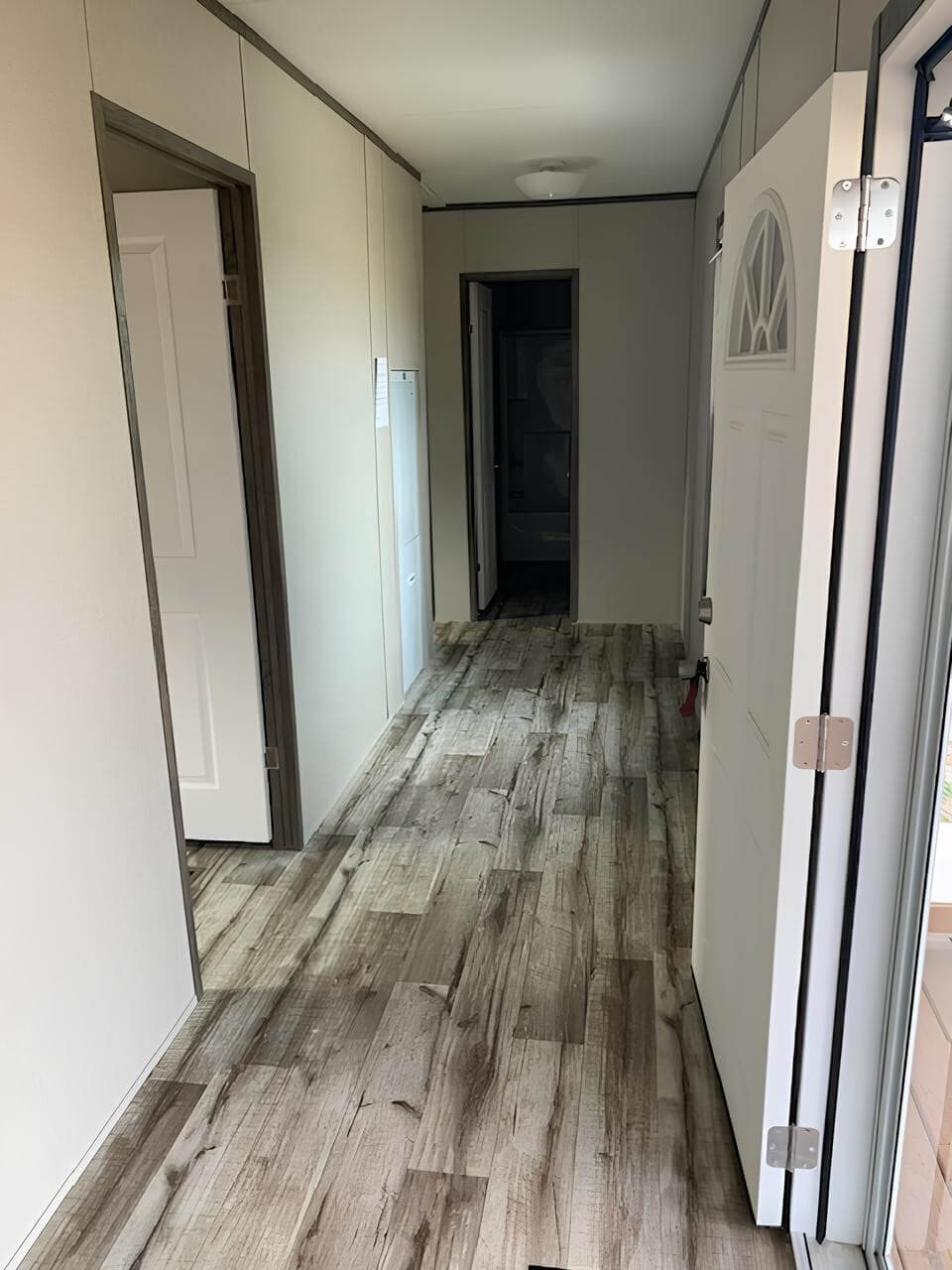 Interior hallway with wood-look flooring in The Cuatro manufactured home