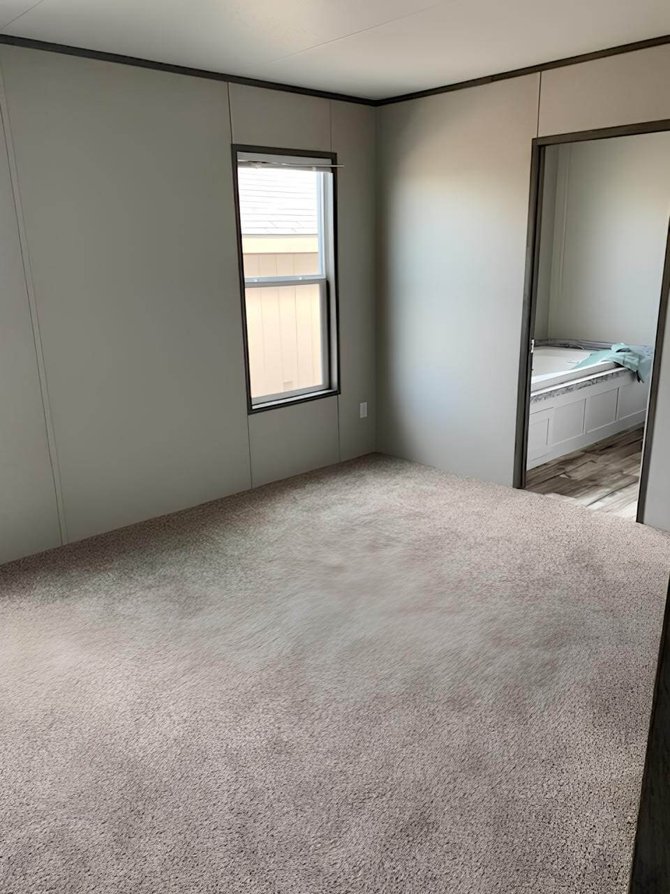 Carpeted primary bedroom with private bathroom access in The Cuatro