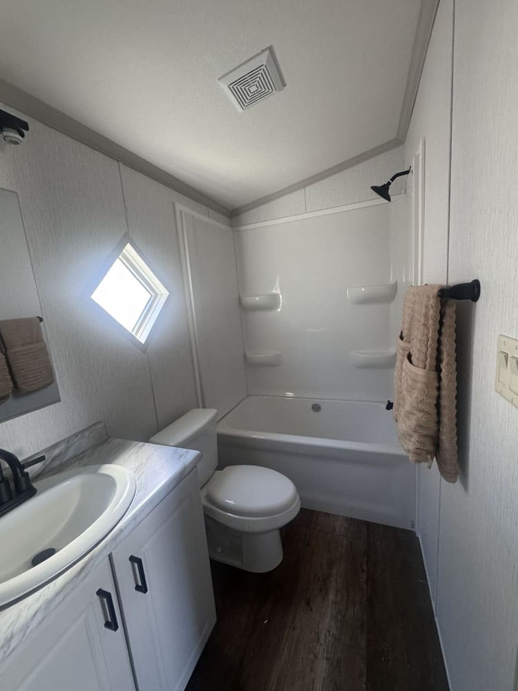 Guest bathroom with tub and vanity at Premier Homes of Conroe
