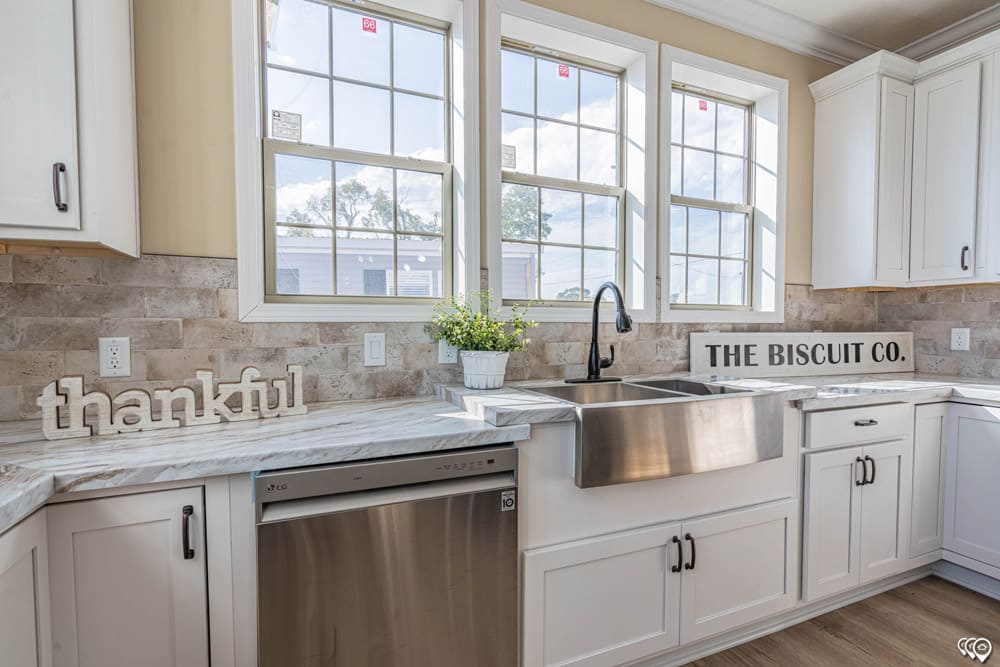 Farmhouse sink and dishwasher beneath kitchen windows in The Woodland