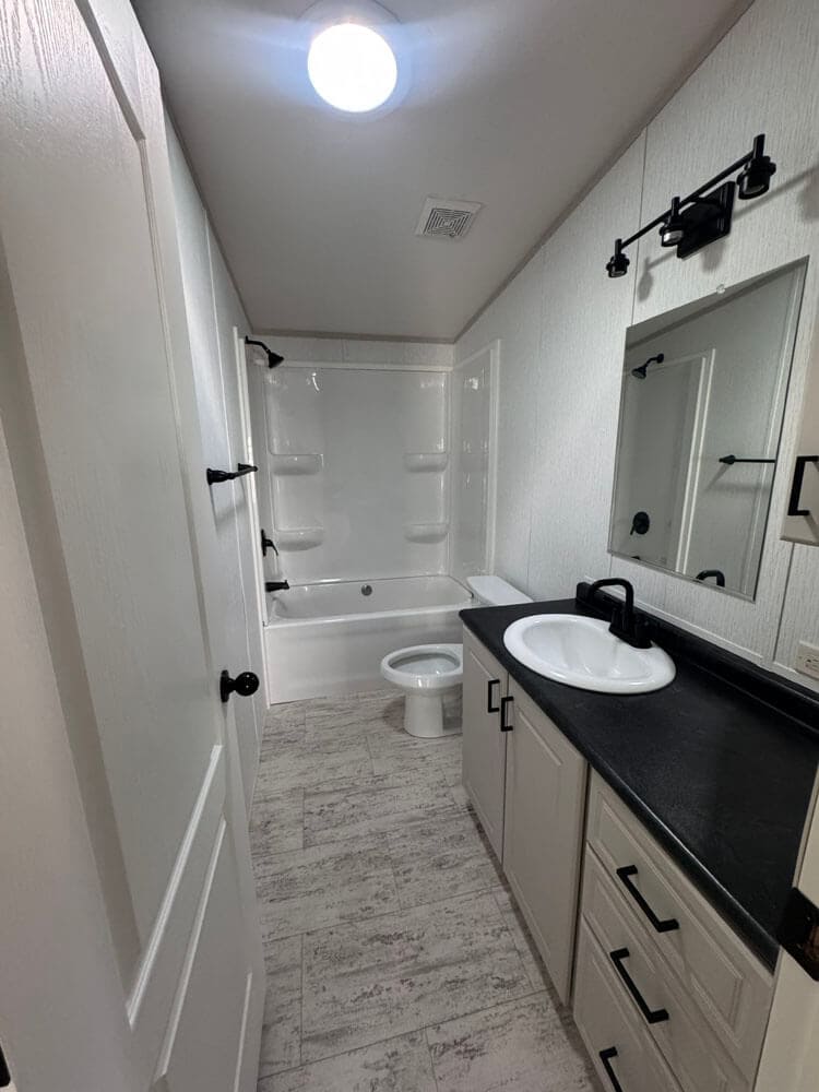 Guest bathroom with tub and vanity in The Lucia manufactured home