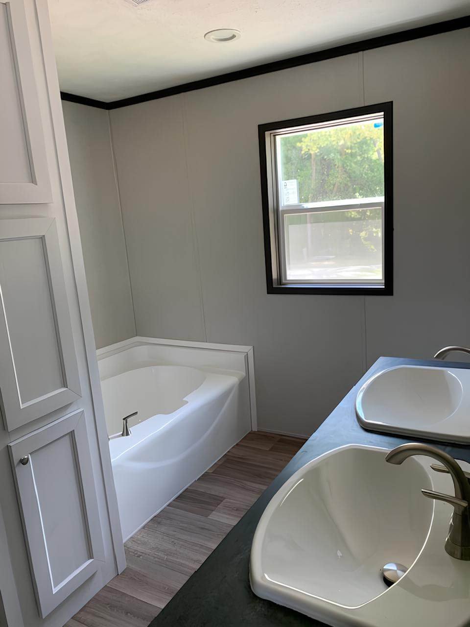Primary bathroom with dual sinks and soaking tub in The Colossal Ultrawide