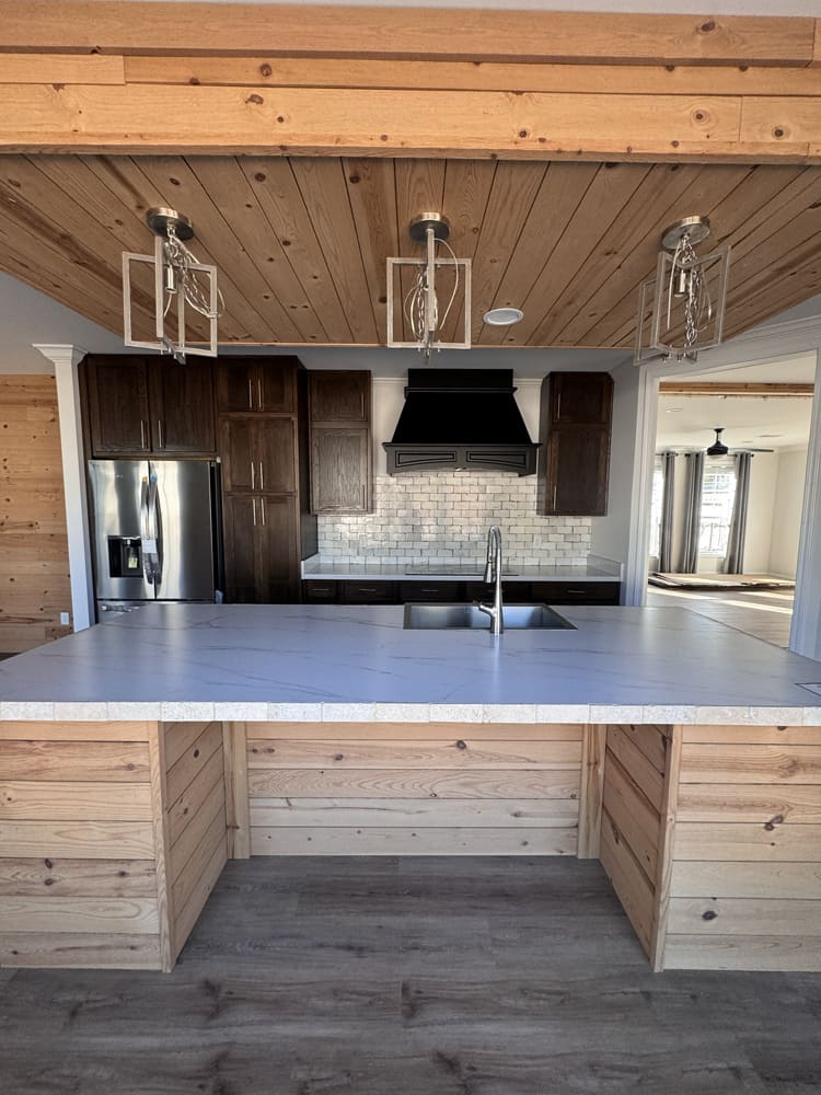 Quartz kitchen island and dark maple cabinets in The Shoreline mobile home