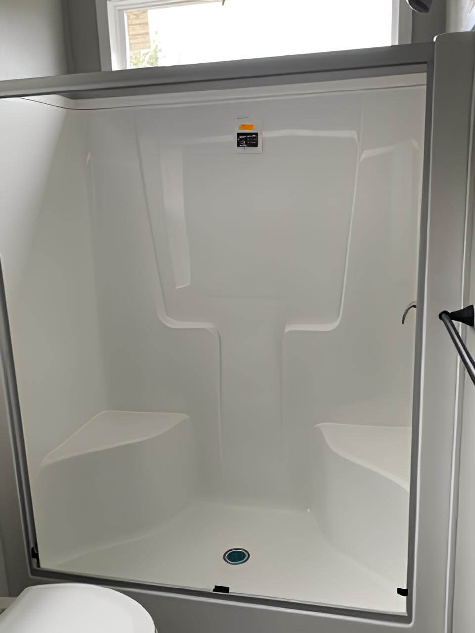 Walk-in shower with built-in corner shelves in the Bobby Jo