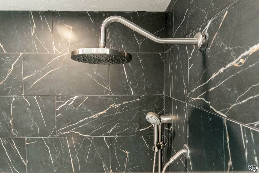 Rainfall shower with marble-look walls in this Cedar Creek modular home