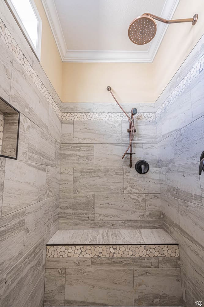 Luxury tiled shower with rainfall showerhead and built-in bench in The Woodland