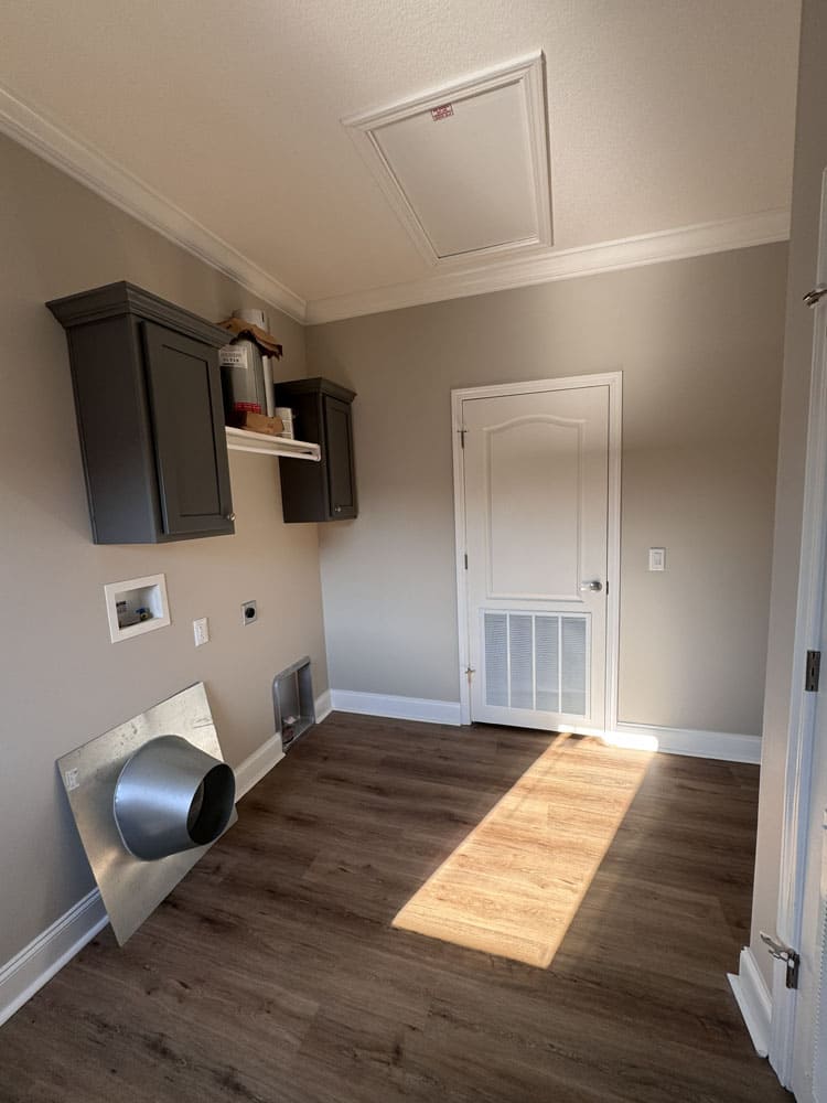 Utility room with laundry hookups and storage cabinets in The Lilly II