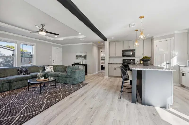 Open kitchen with center island overlooking the living room in The Carol by Champion Homes