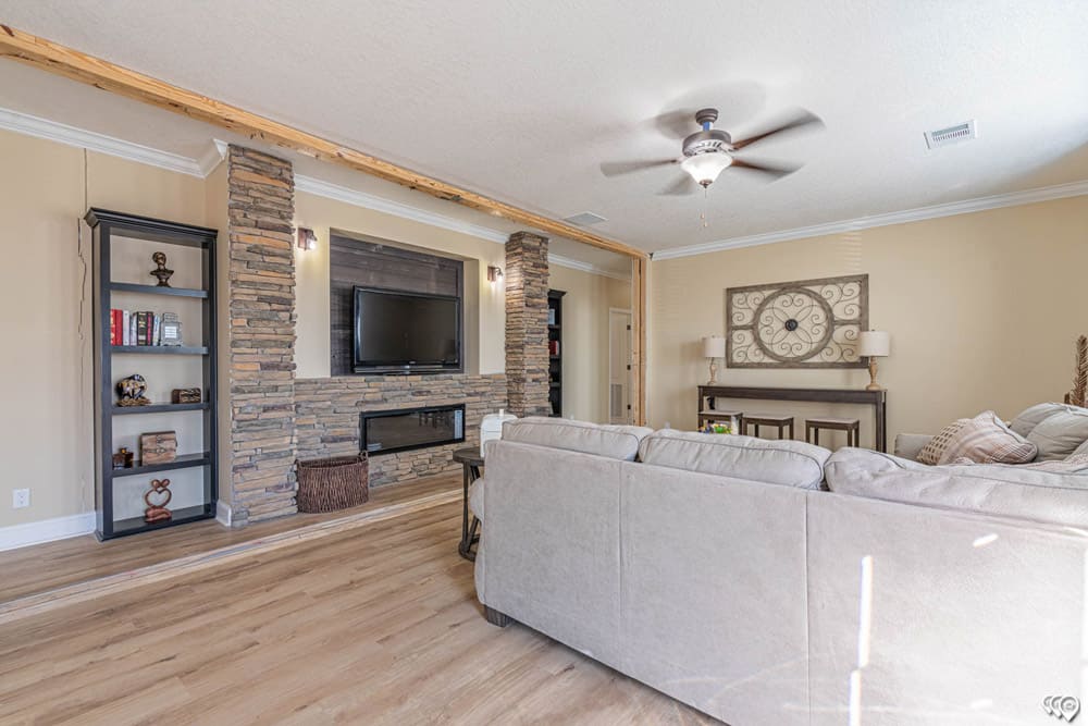 The Woodland living room with stone fireplace and built-in shelving