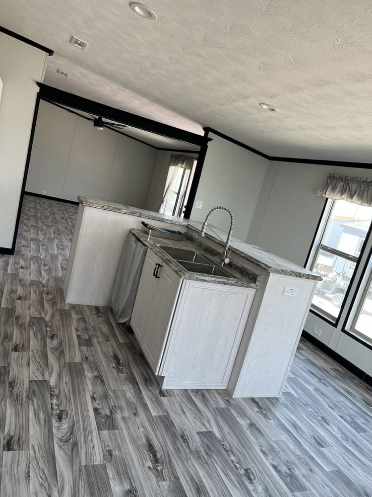 Kitchen peninsula with sink and dishwasher in the Legacy C-3256-32B 32x56 home in El Paso