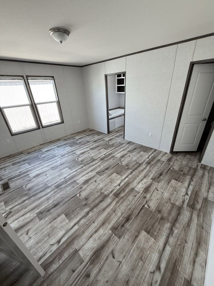 Bedroom with adjoining bathroom doorway in the Jessup Jackson 3-bedroom manufactured home