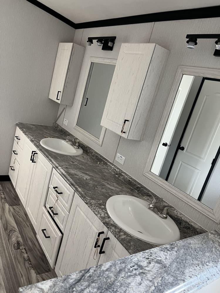 Long double vanity with overhead cabinets in the Legacy C-3256-32B 32x56 home in El Paso