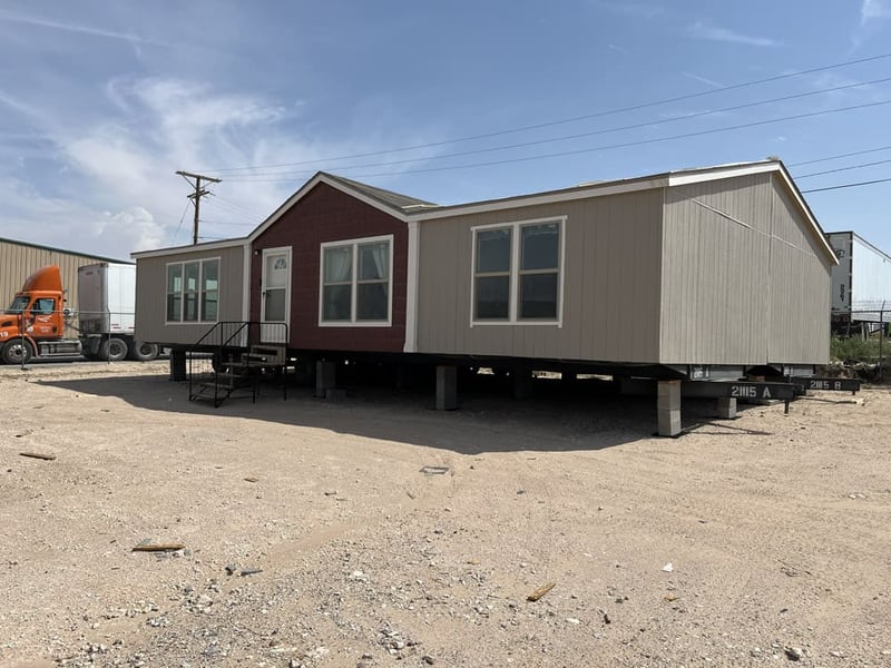 Double-wide exterior with taupe siding and red entry section in the Legacy C-3256-32B 32x56 home in El Paso