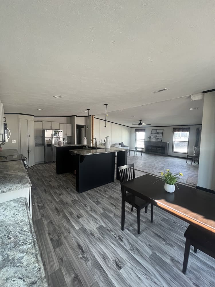 Dining table with views of the island and fireplace in the Legacy FG-H-326432AD 32x64 home in El Paso