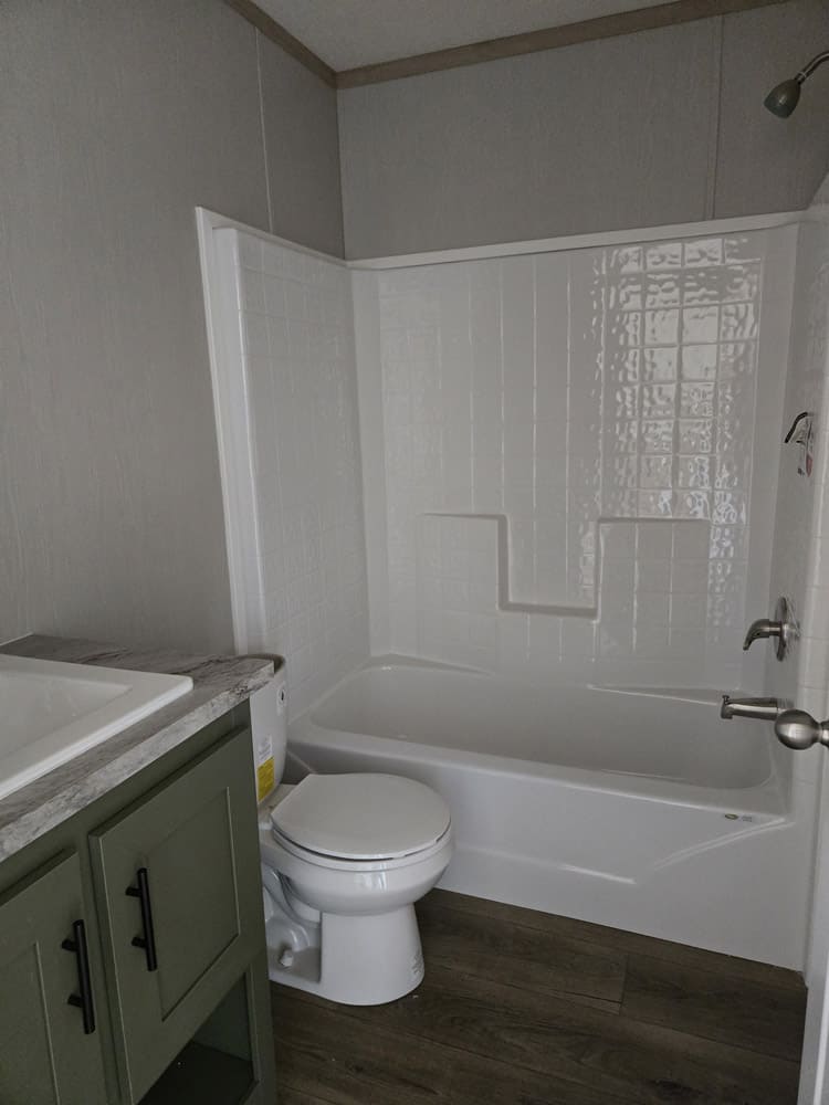 Bathroom with green vanity and tub-shower combination in the Clayton Epic Hudson 3-bedroom manufactured home