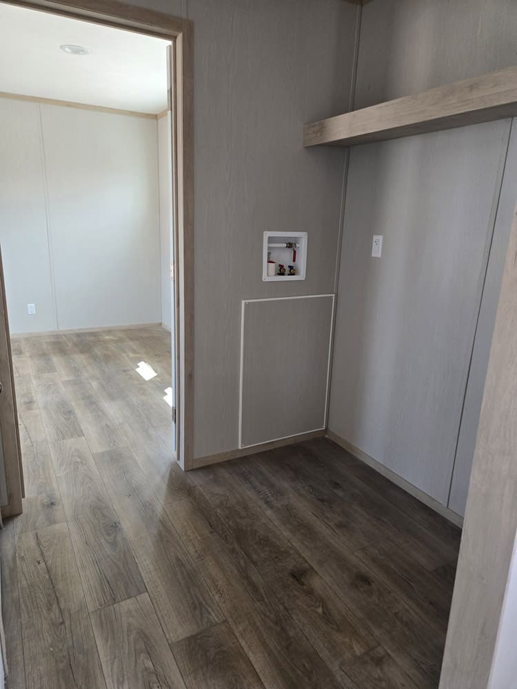 Laundry hookups beneath a storage shelf in the Clayton Epic Hudson 3-bedroom manufactured home