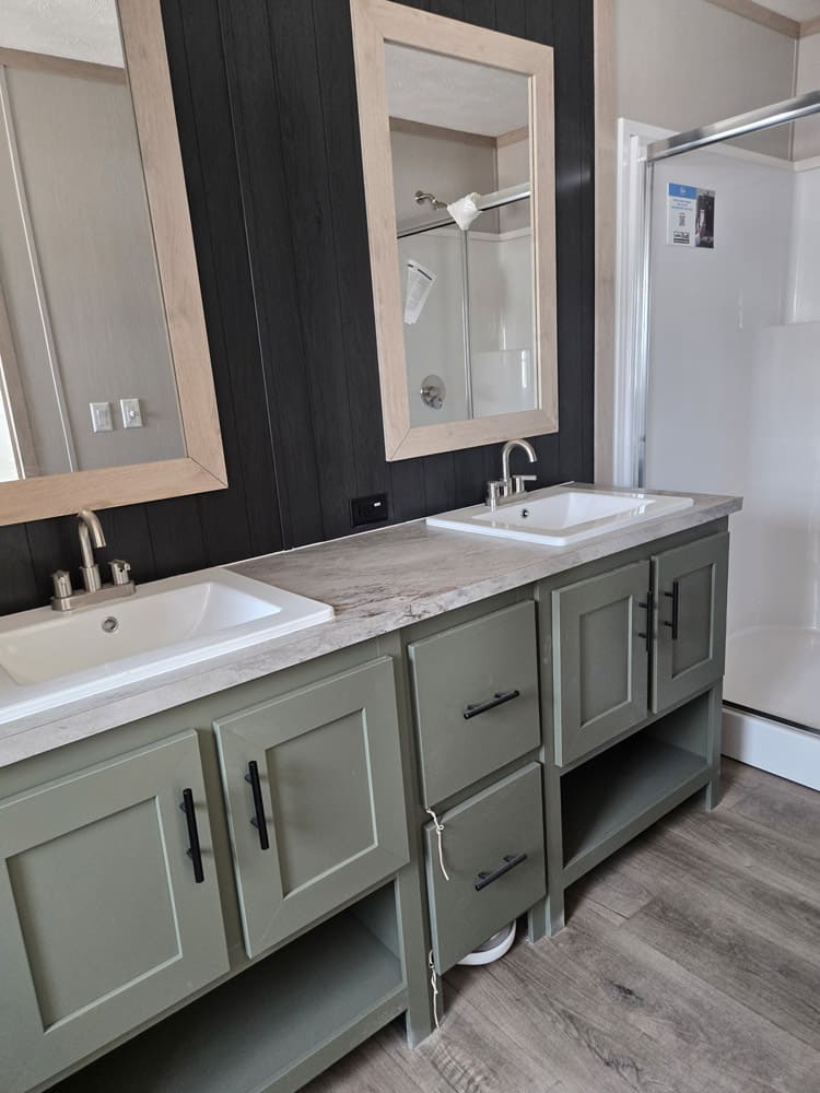 Green double vanity with framed mirrors in the Clayton Epic Hudson 16x76 home in El Paso