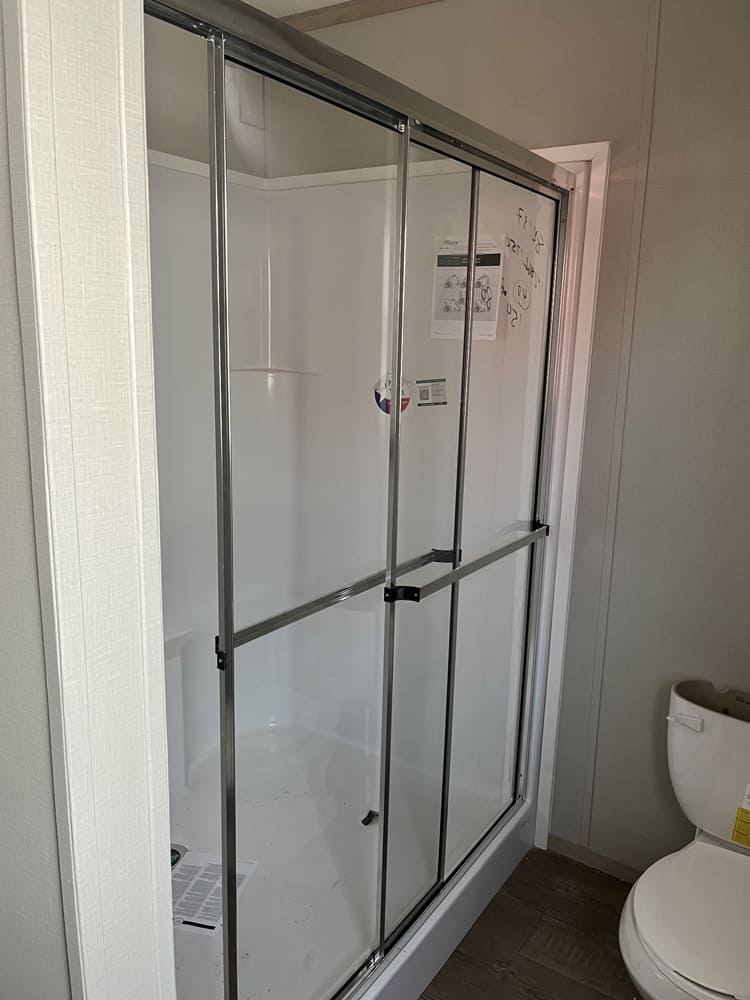 Glass shower enclosure beside the toilet in the Clayton Epic Mariner home in El Paso
