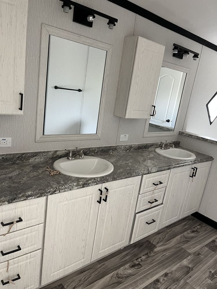 Double vanity and bathroom storage cabinets in the Legacy C-3256-32B 32x56 home in El Paso