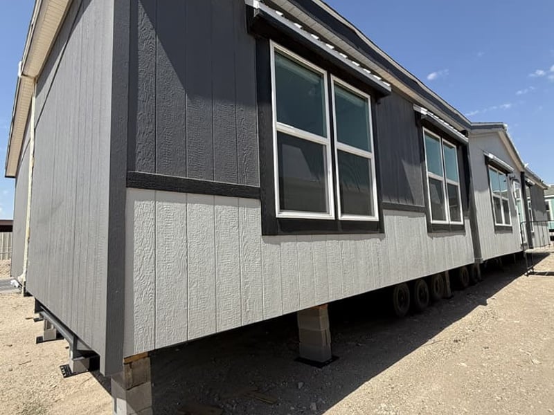 Angled exterior with two-tone gray siding and dark window trim in the Jessup Madison 32x64 home in El Paso