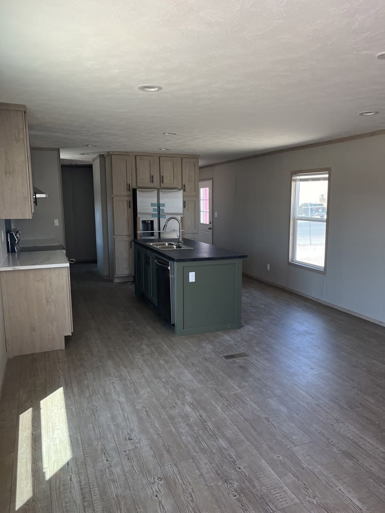 Kitchen with green island and light cabinetry in the Clayton Epic Mariner 3-bedroom manufactured home