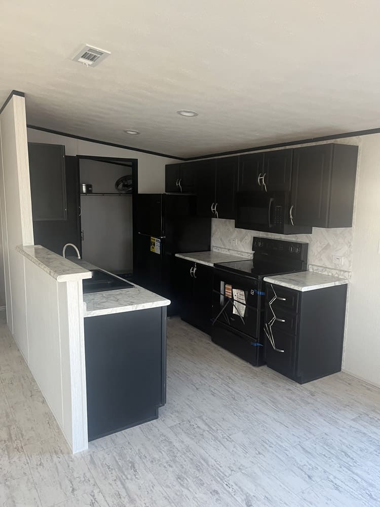 Kitchen with dark cabinets and appliances in the Legacy S-2856-32 FLP home in El Paso