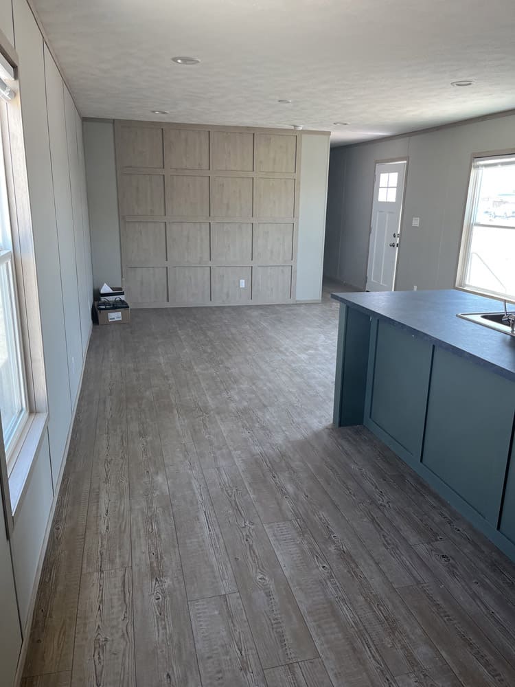 Living room with wood-look accent wall in the Clayton Epic Mariner home in El Paso
